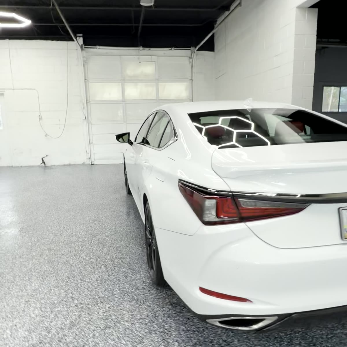 White Lexus rear-3/4 angle after ceramic coating, hexagon lights reflecting in rear window